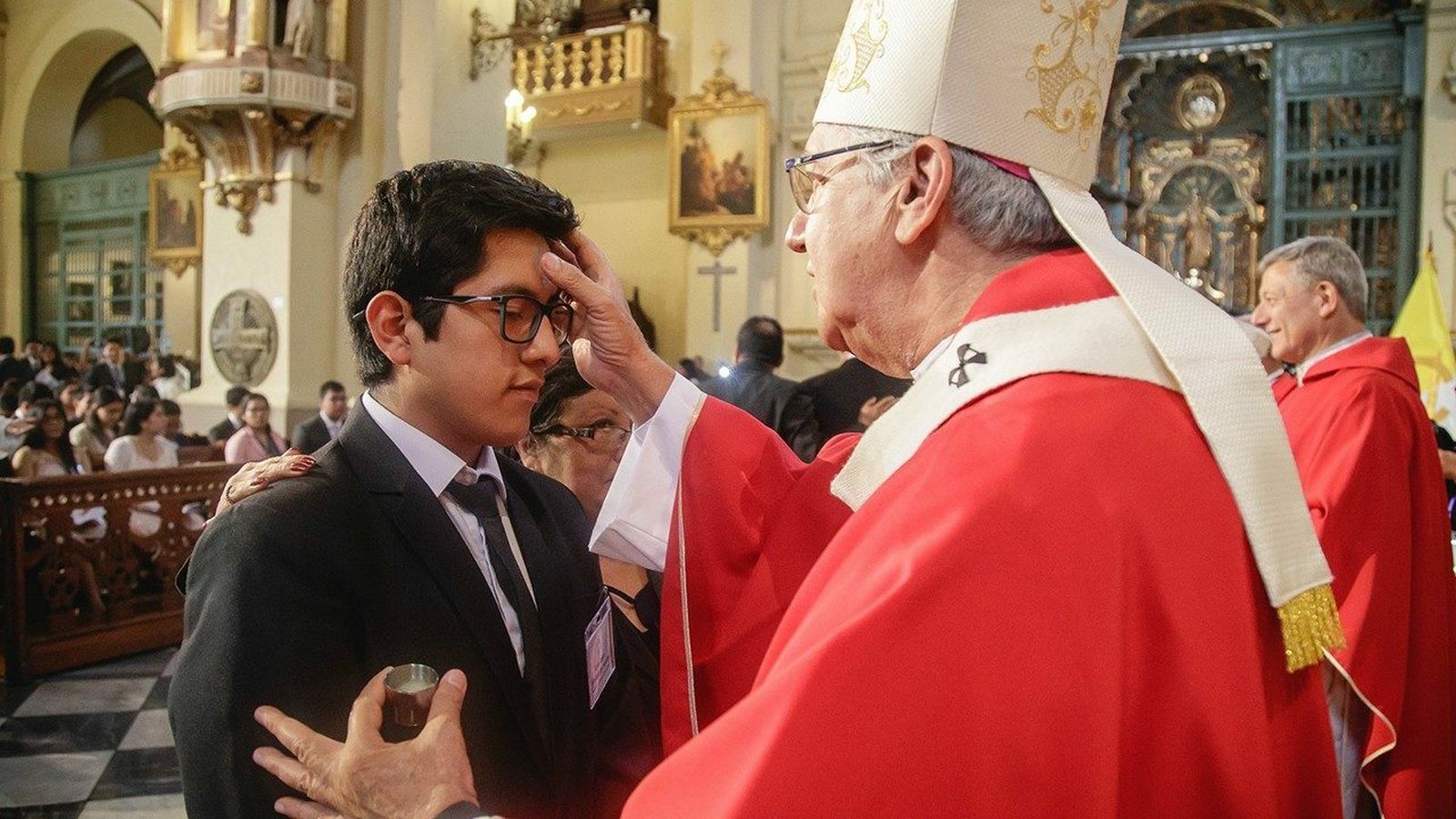 Monseñor Castillo unge a un estudiante en la Confirmación Universitaria celebrada en la catedral de Lima