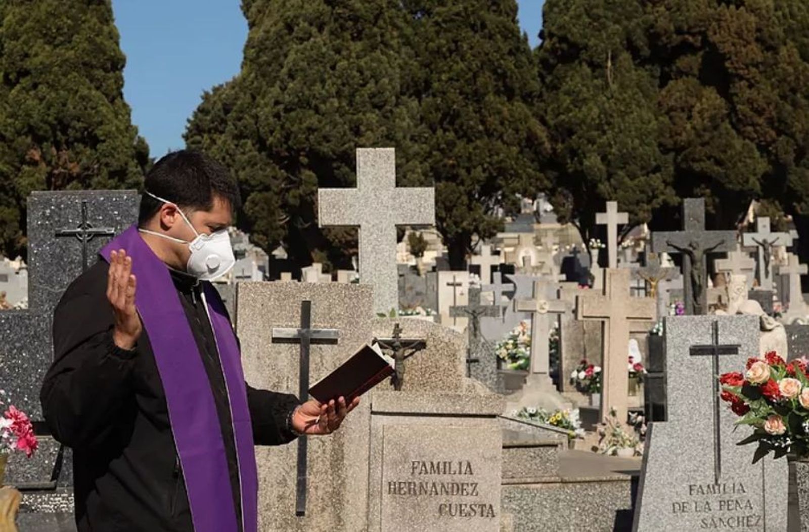 Sacerdote reza un responso en el cementerio