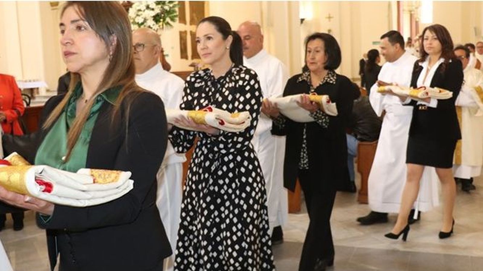 Procesión de mujeres con las vestiduras de sus maridos