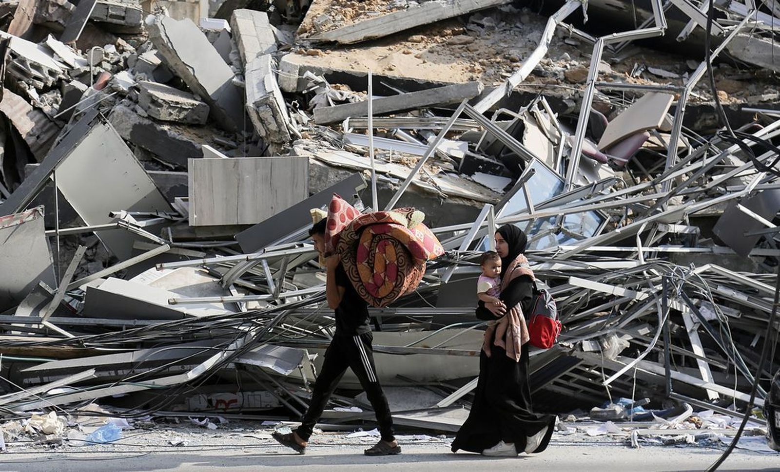 Habitantes de Gaza caminan con sus pertenencias en medio de la destrucción