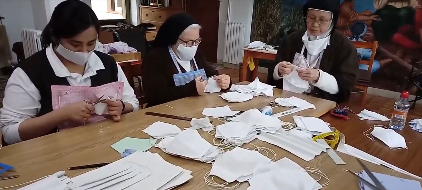 MOnjas hacen mascarillas para el coronavirus