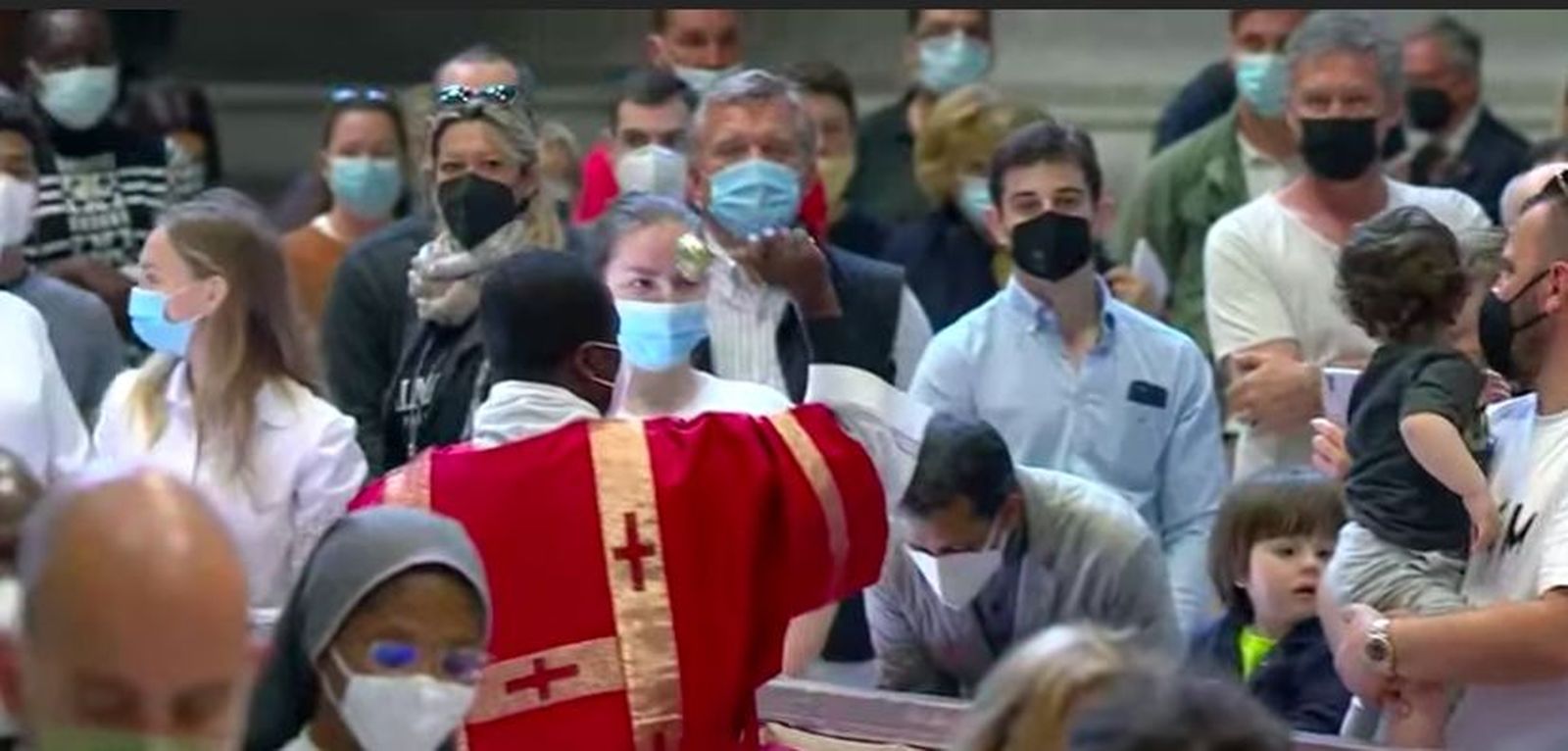Un sacerdote bendice con el agua a los fieles