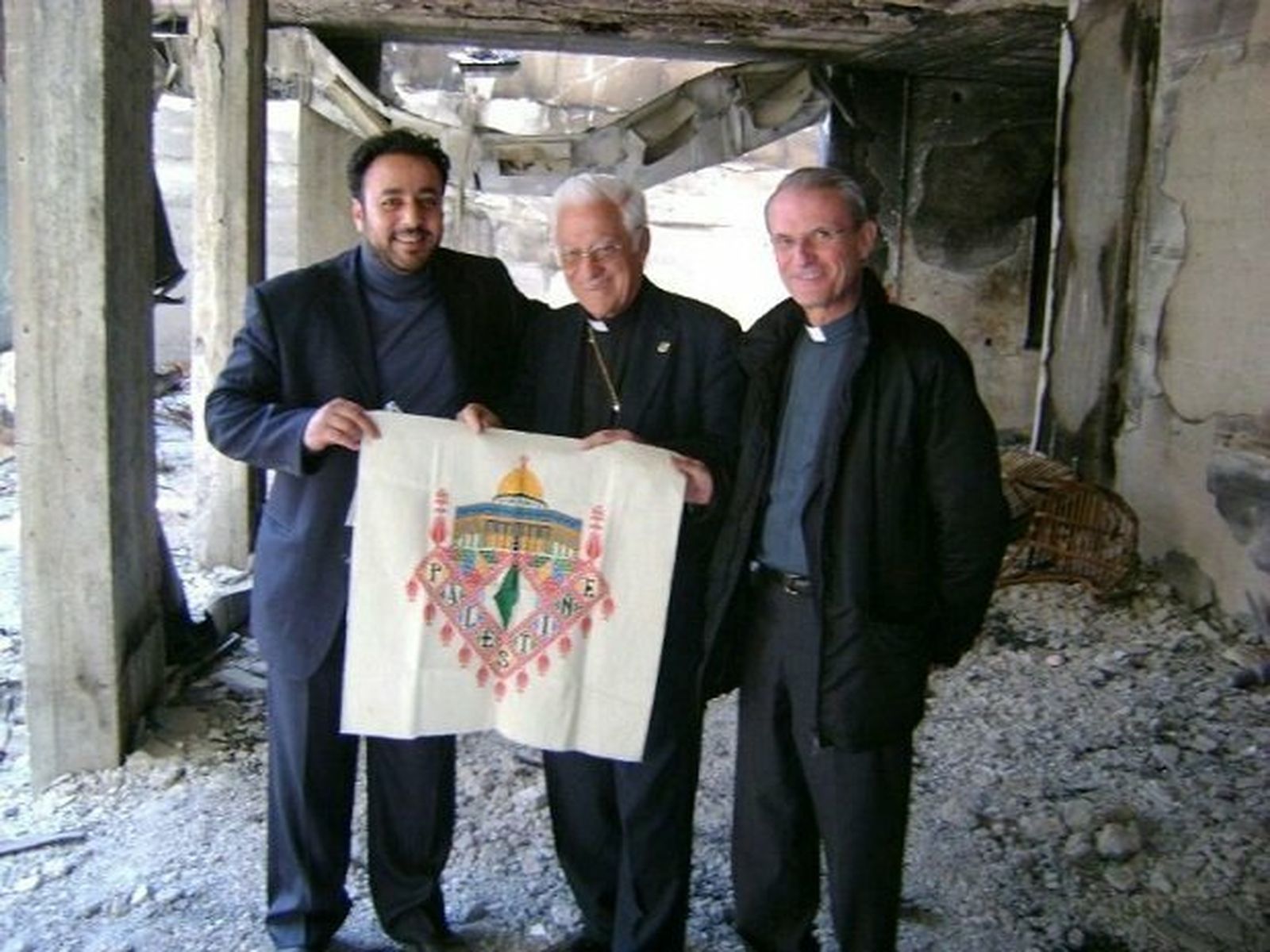 El Padre Ángel y José Vicente sostienen una bandera palestina