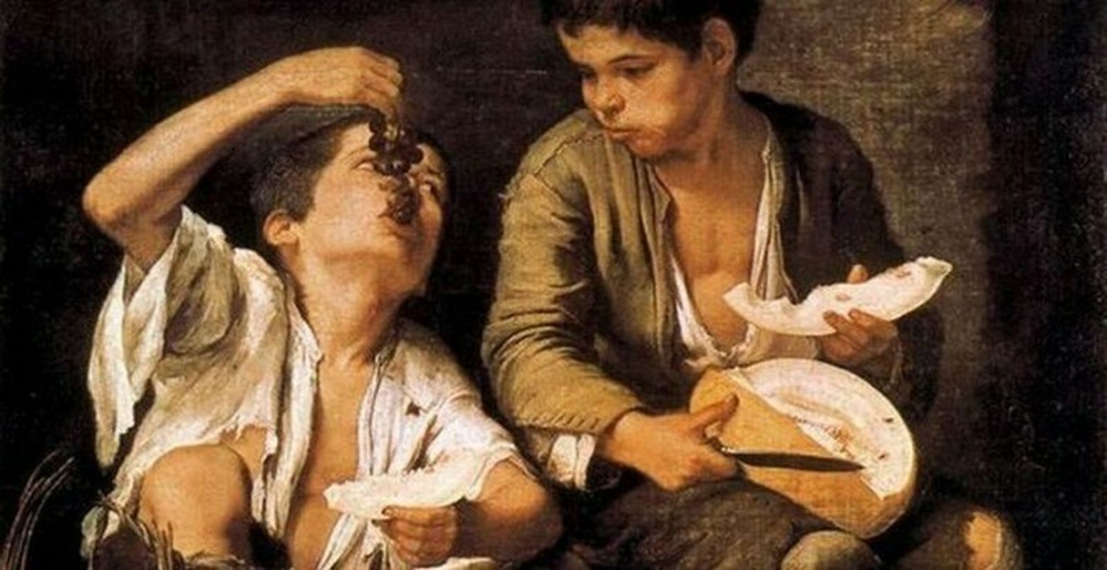 Dos niños comiendo melón y uvas