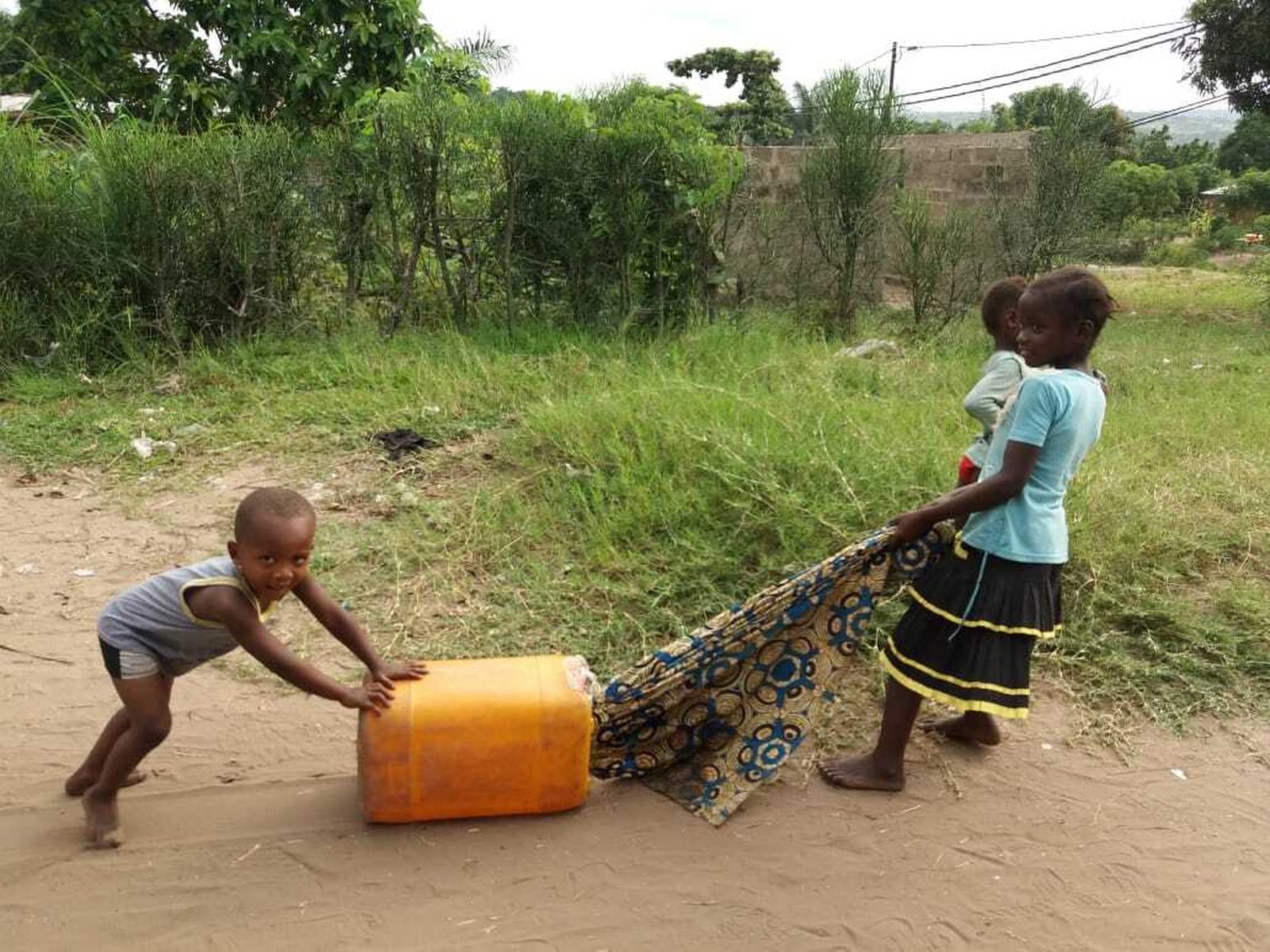 Niños acarreando un bidón de agua en la comunidad del P. Riaño