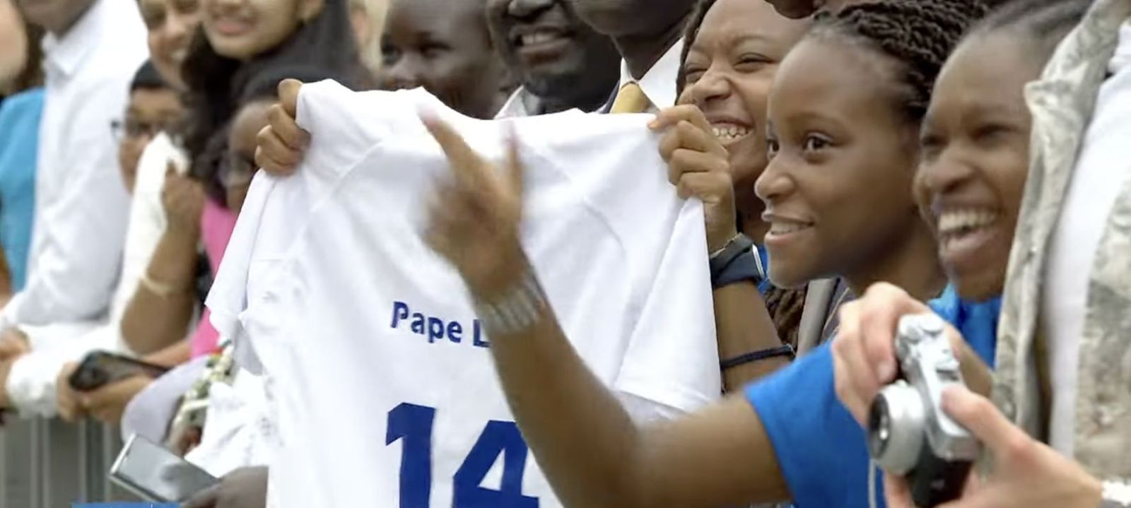 Una niña, con una camiseta de León XIV