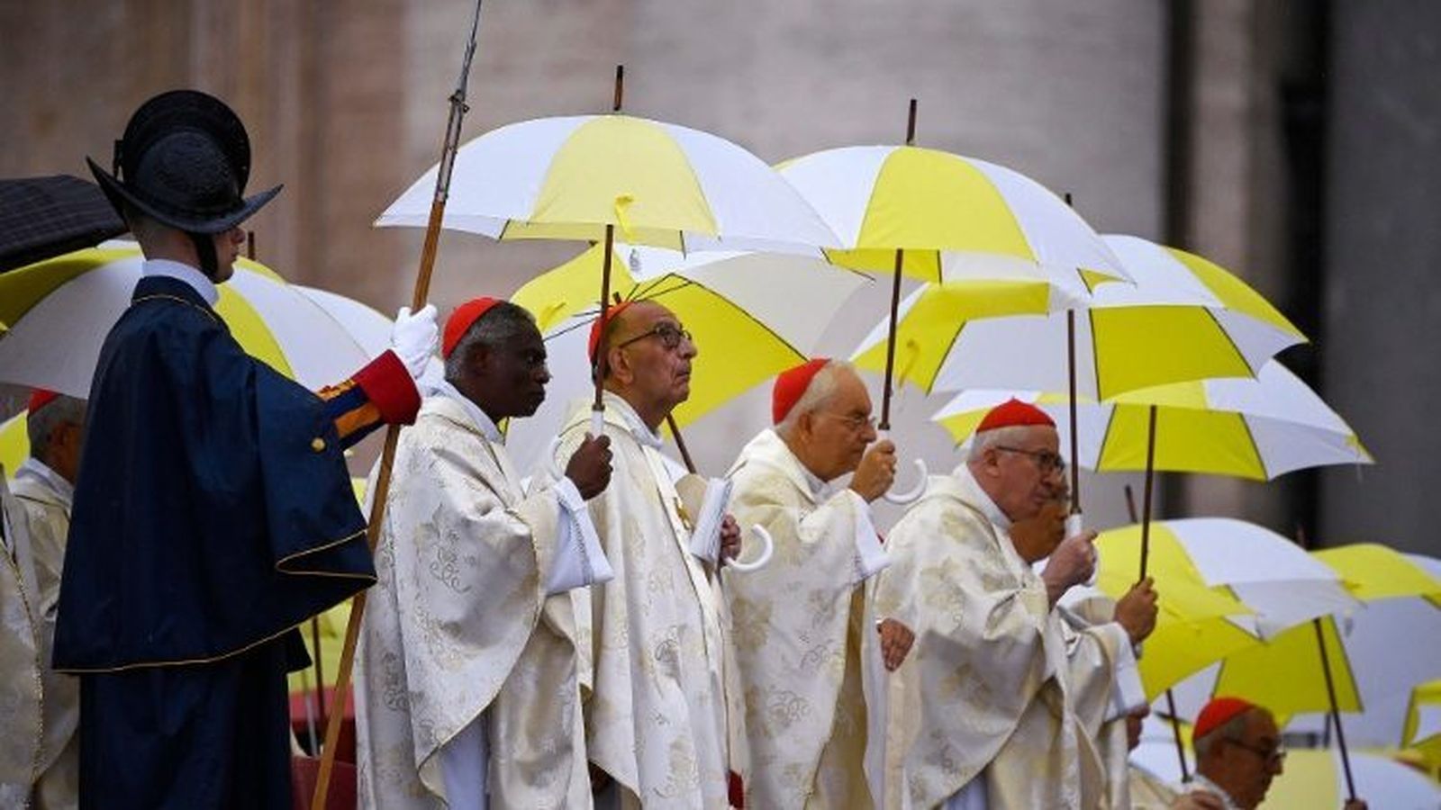 Omella, junto a otros cardenales, se protege de la lluvia durante la beatificación