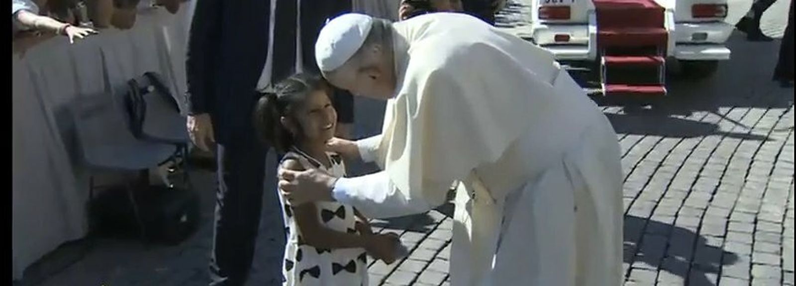 Francisco acaricia y conversa con una niña