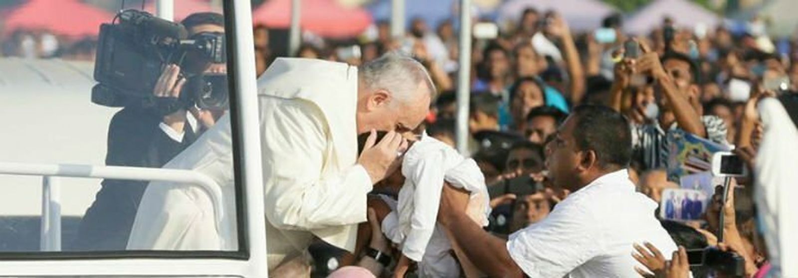 El Papa besa a un niño en la canonización de José Vaz