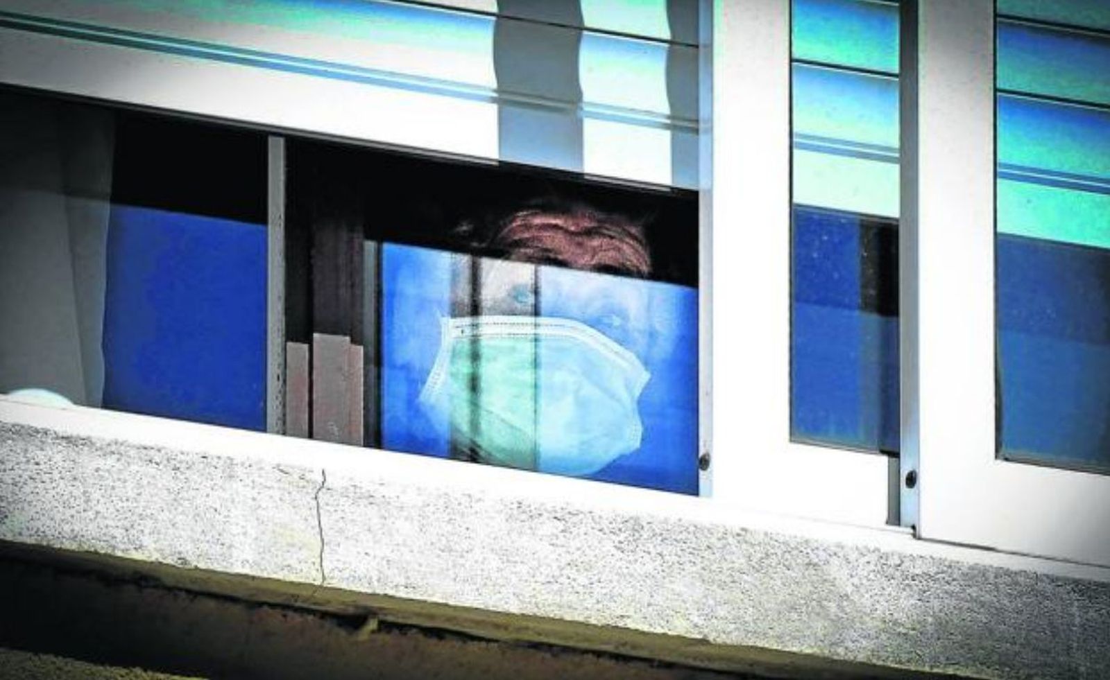 Anciana en la ventana de una residencia