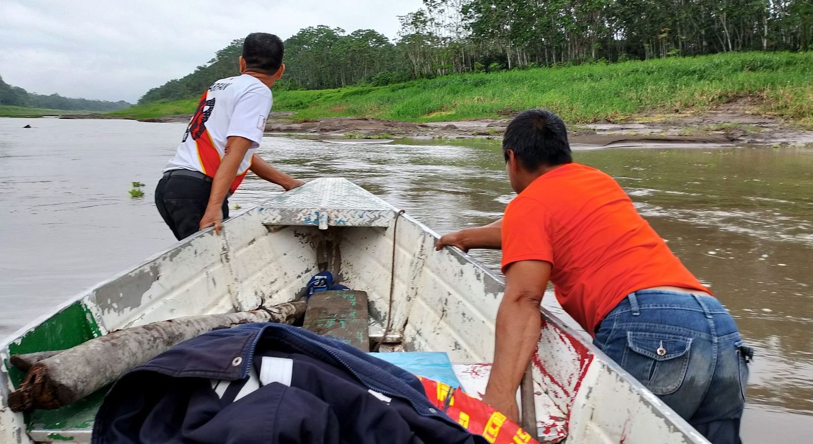 Empujando el bote varado por el bajo nivel del río