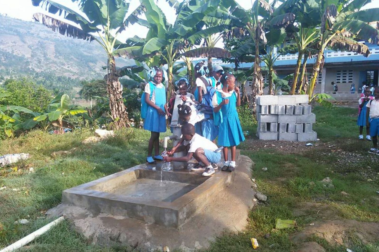 Estudiantes en una fuente de agua potable en una escuela católica de Jérémie