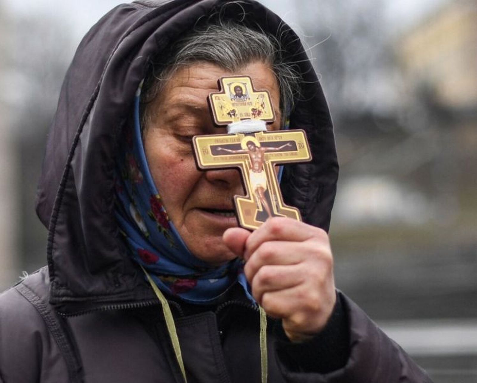 Una mujer se refugia en el crucifijo ortodoxo