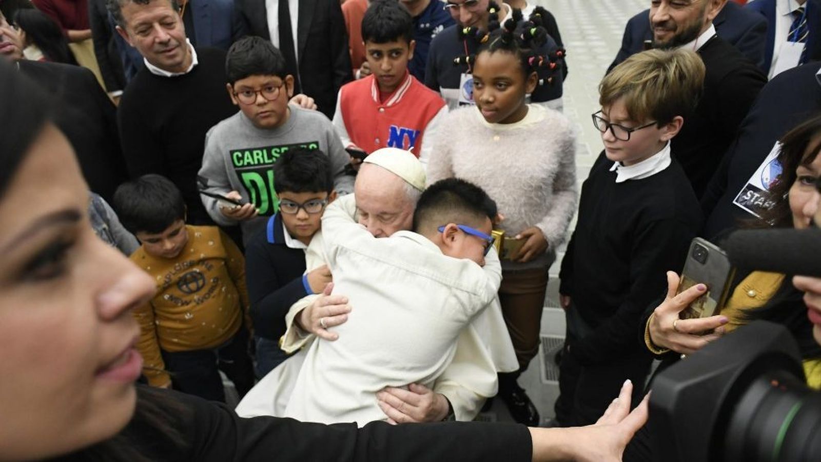 Un niño se abraza al Papa durante su visita al dispensario de Santa Marta