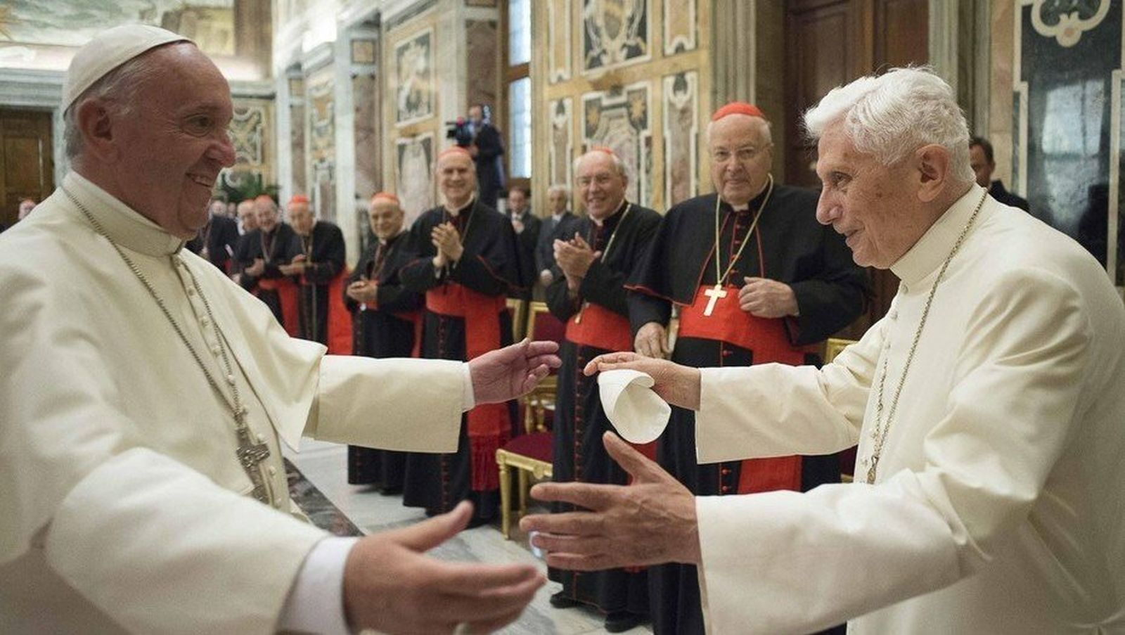 Los dos papas se abrazan ante los cardenales