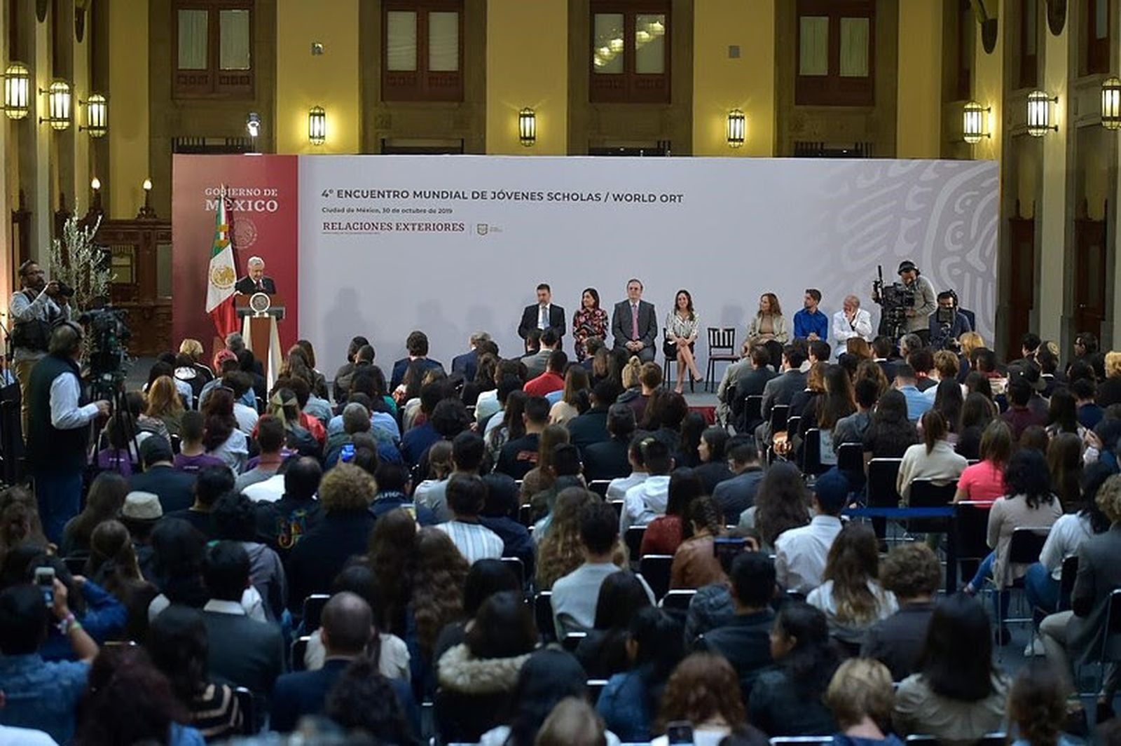 Los jóvenes participantes del IV Encuentro Mundial de Scholas junto a AMLO en el Palacio Nacional