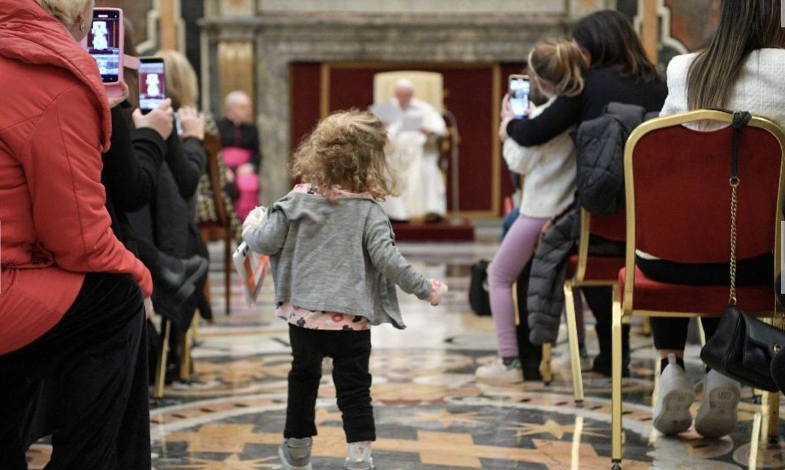 Una niña se encamina a saludar al Papa durante la audiencia