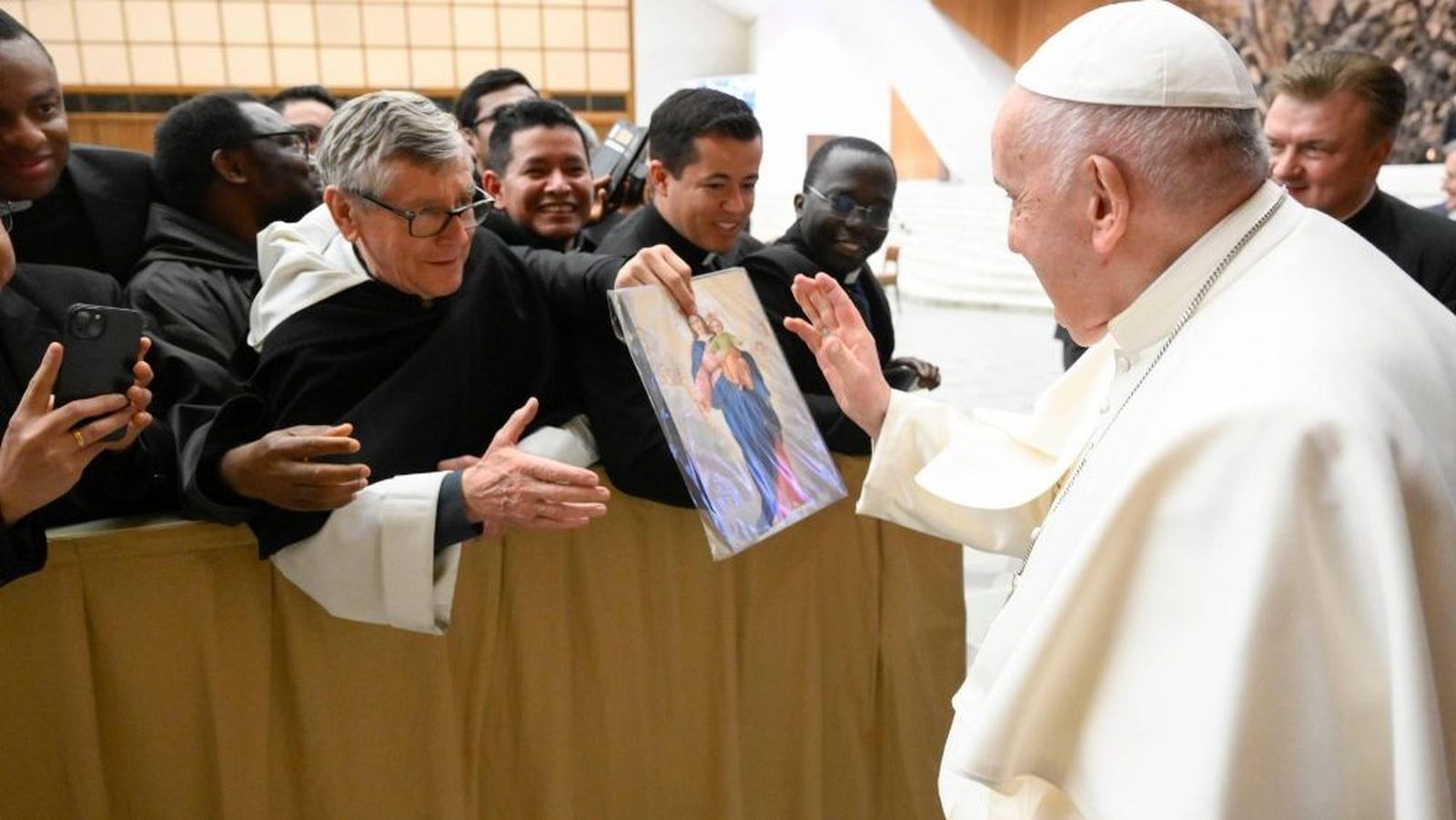 Un religioso ofrece una pintura al Papa durante la Audiencia