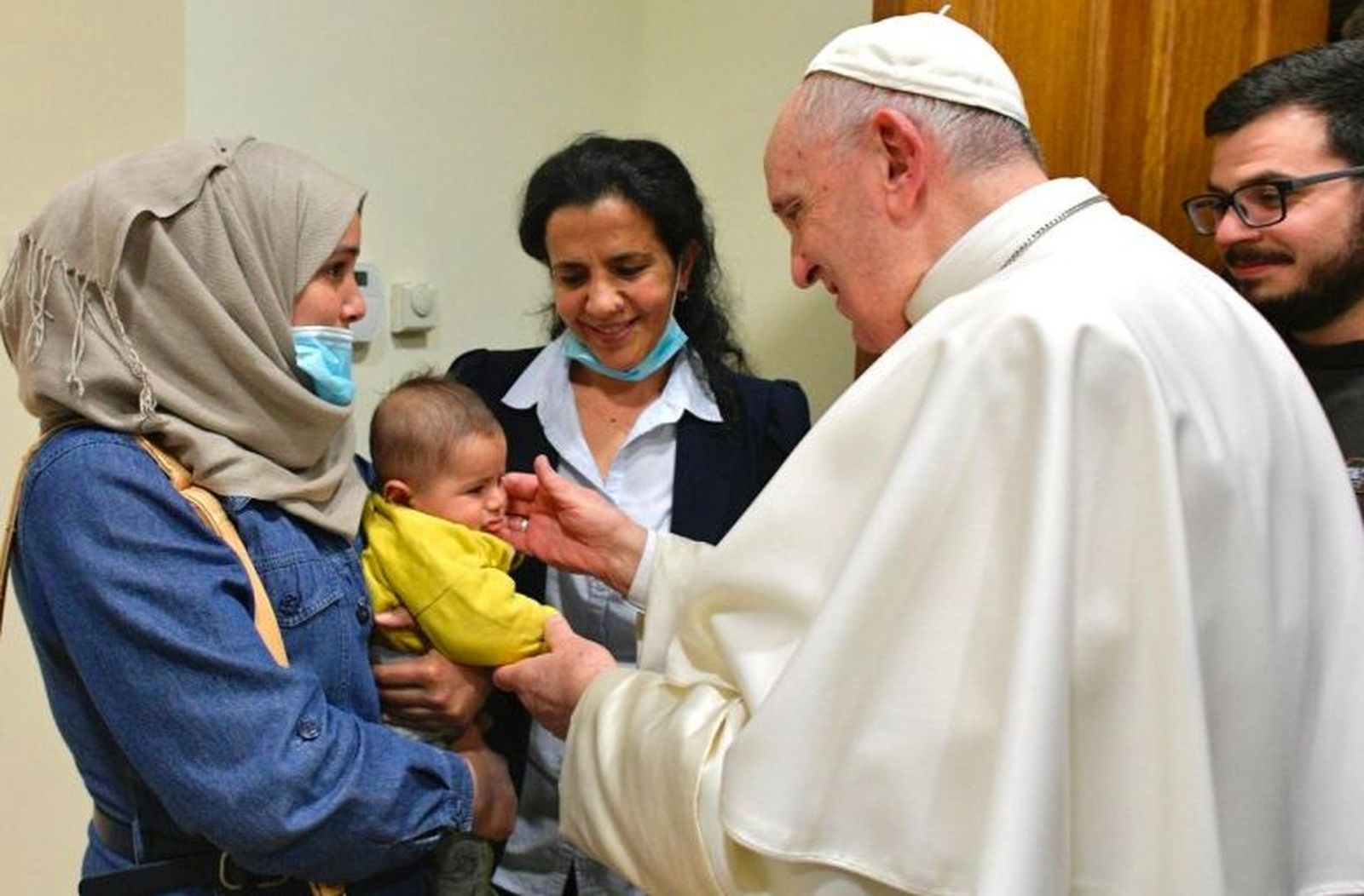 Francisco abraza a un niño y su madre