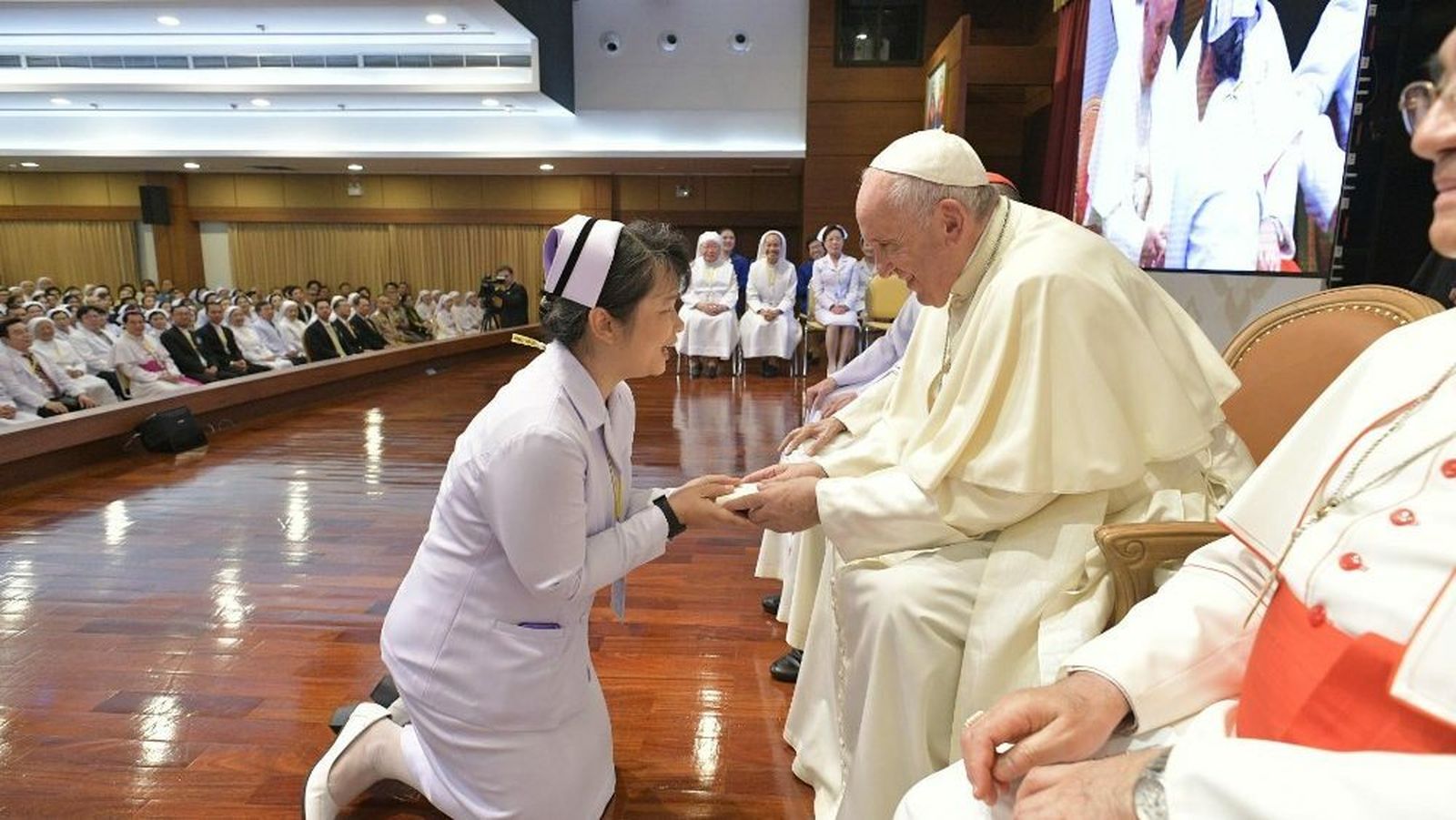 Una enfermera se arrodilla ante el Papa