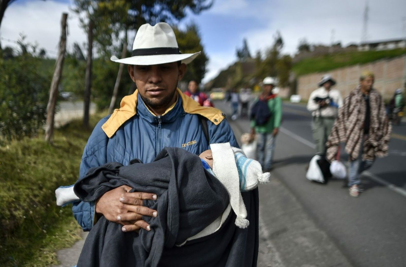 Un migrante venezolano con su hijo en camino hacia Perú