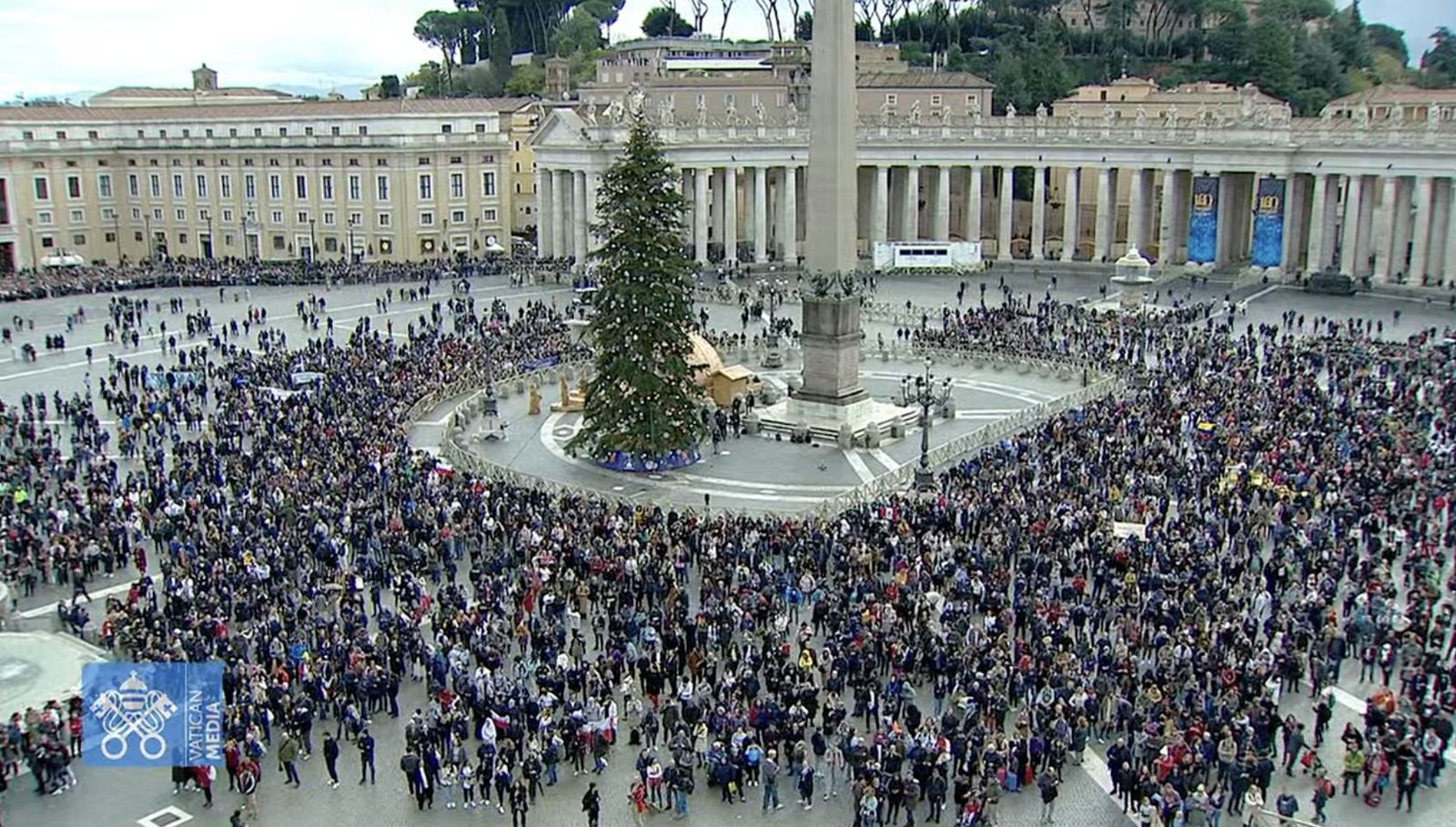 Fieles en la plaza del San Pedro, adornada con el abeto y el belén