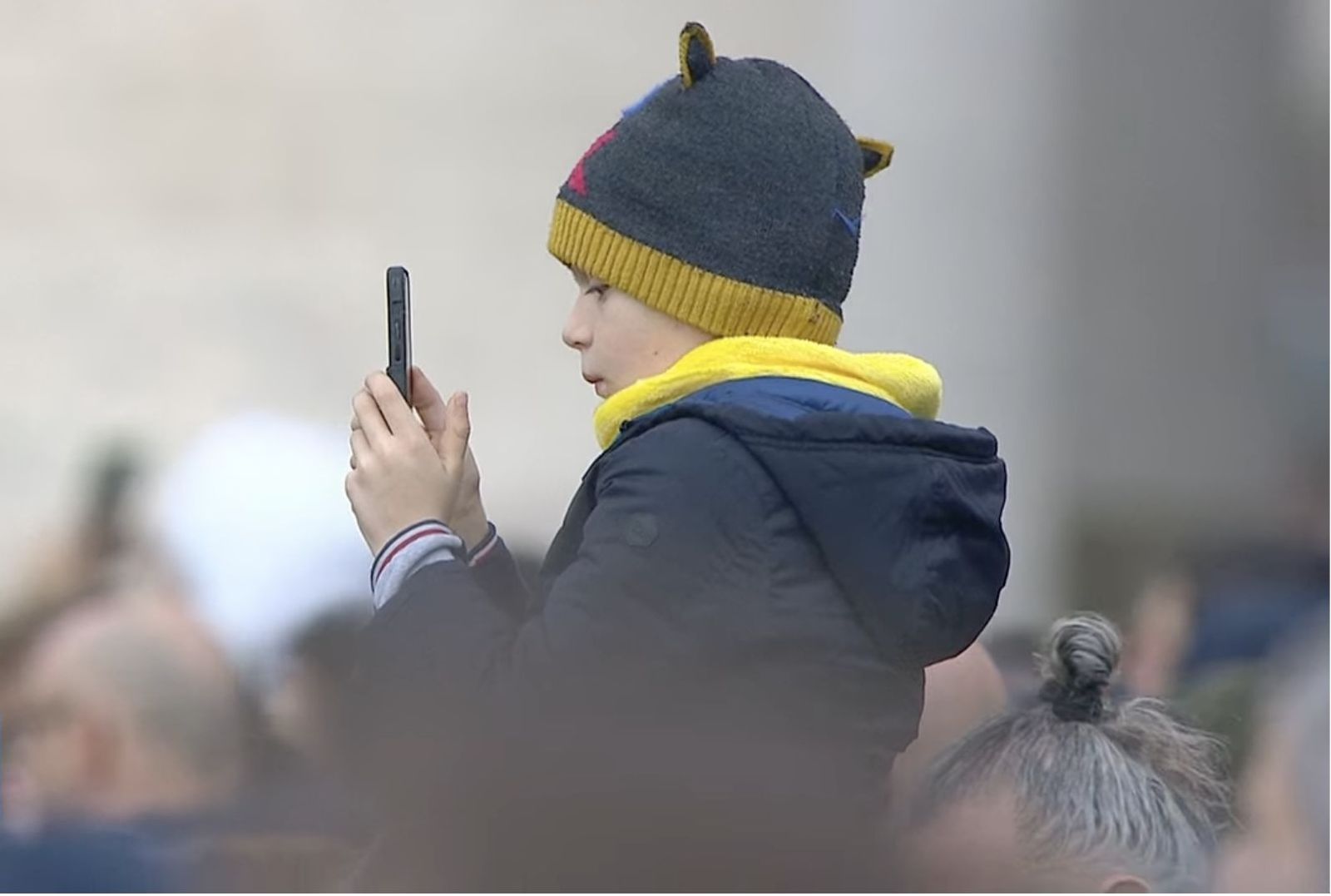 Un niño sigue en su móvil la intervención del Papa