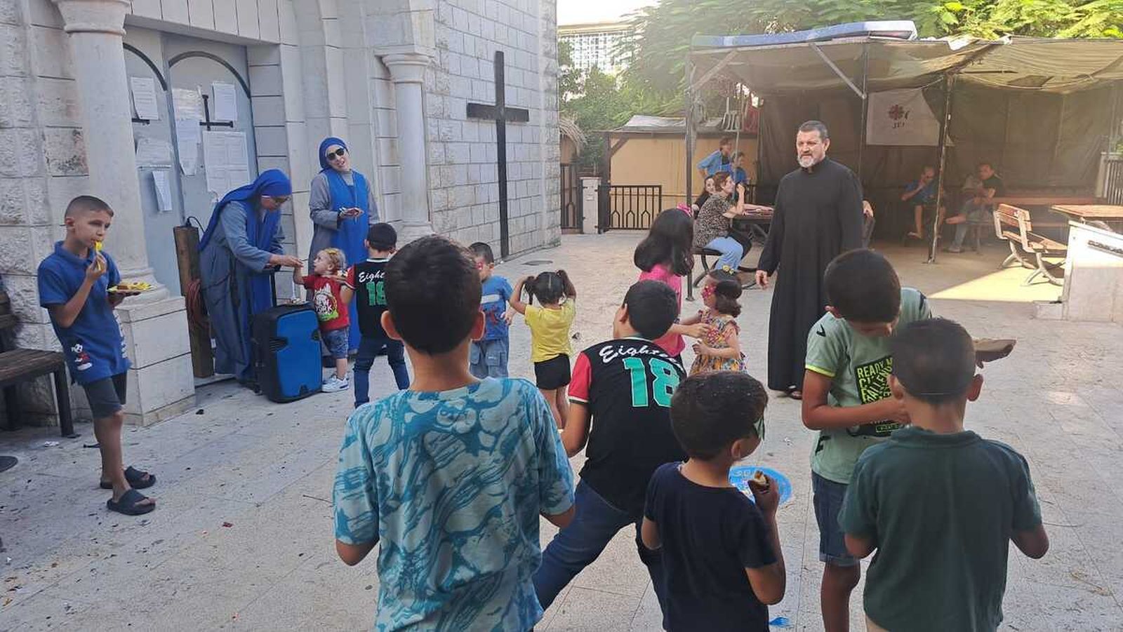 Hora del almuerzo para unos niños en el patio de la parroquia en Gaza