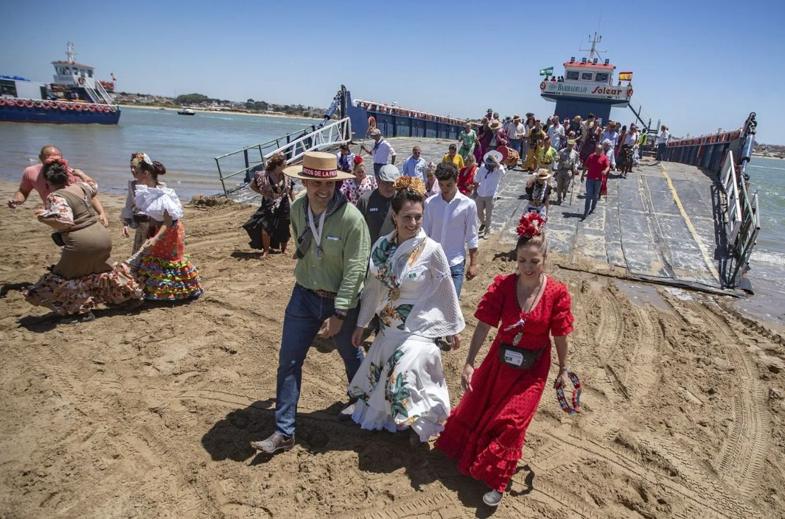 Romeros cruzan el Guadalquivir en barcazas