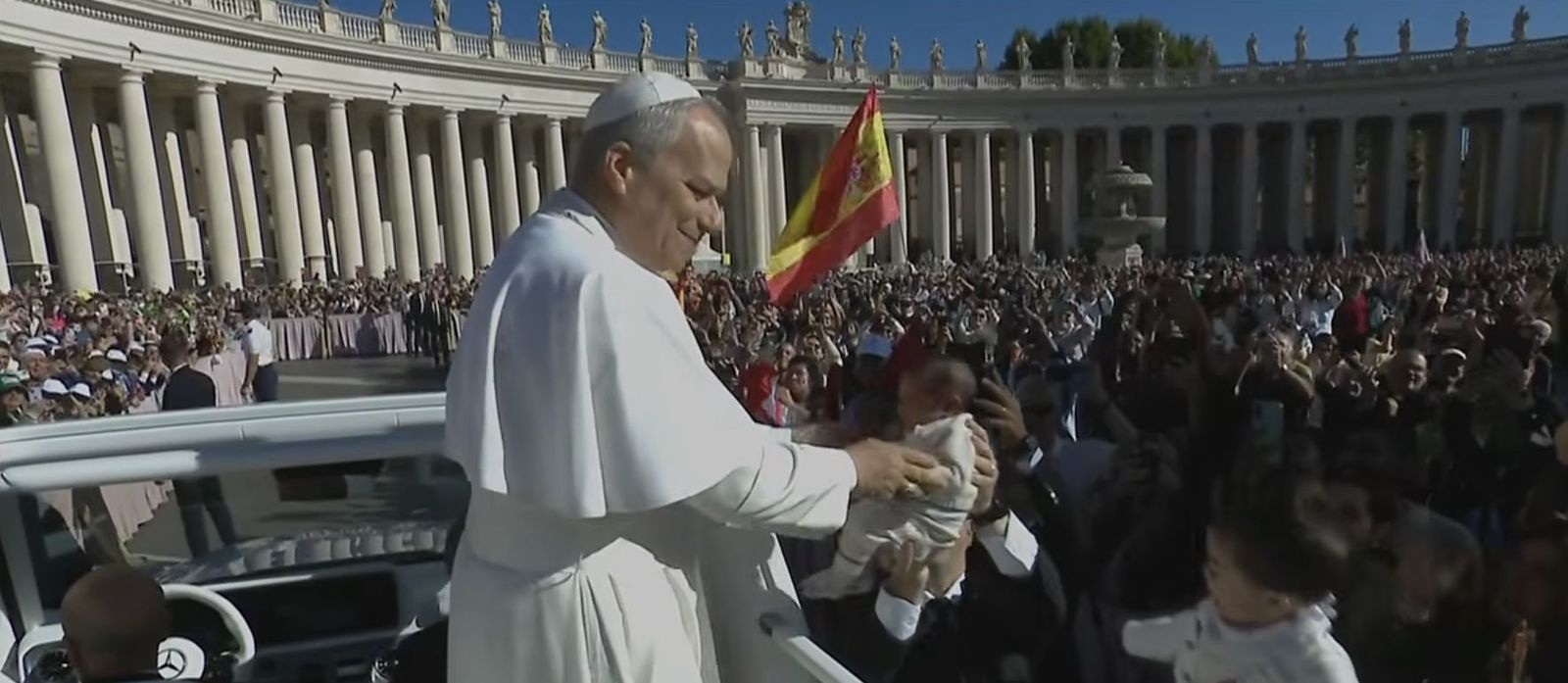 El Papa besa a un niño ante una bandera de España