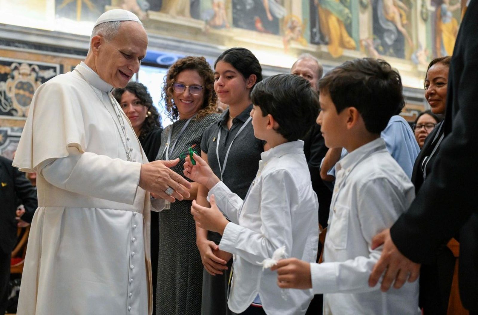 León XIV, durante la audiencia, saluda a unos niños / @Vatican Media