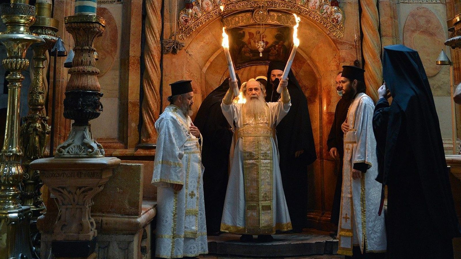 Teofilos III muestra a los fieles las velas con el Fuego Sagrado