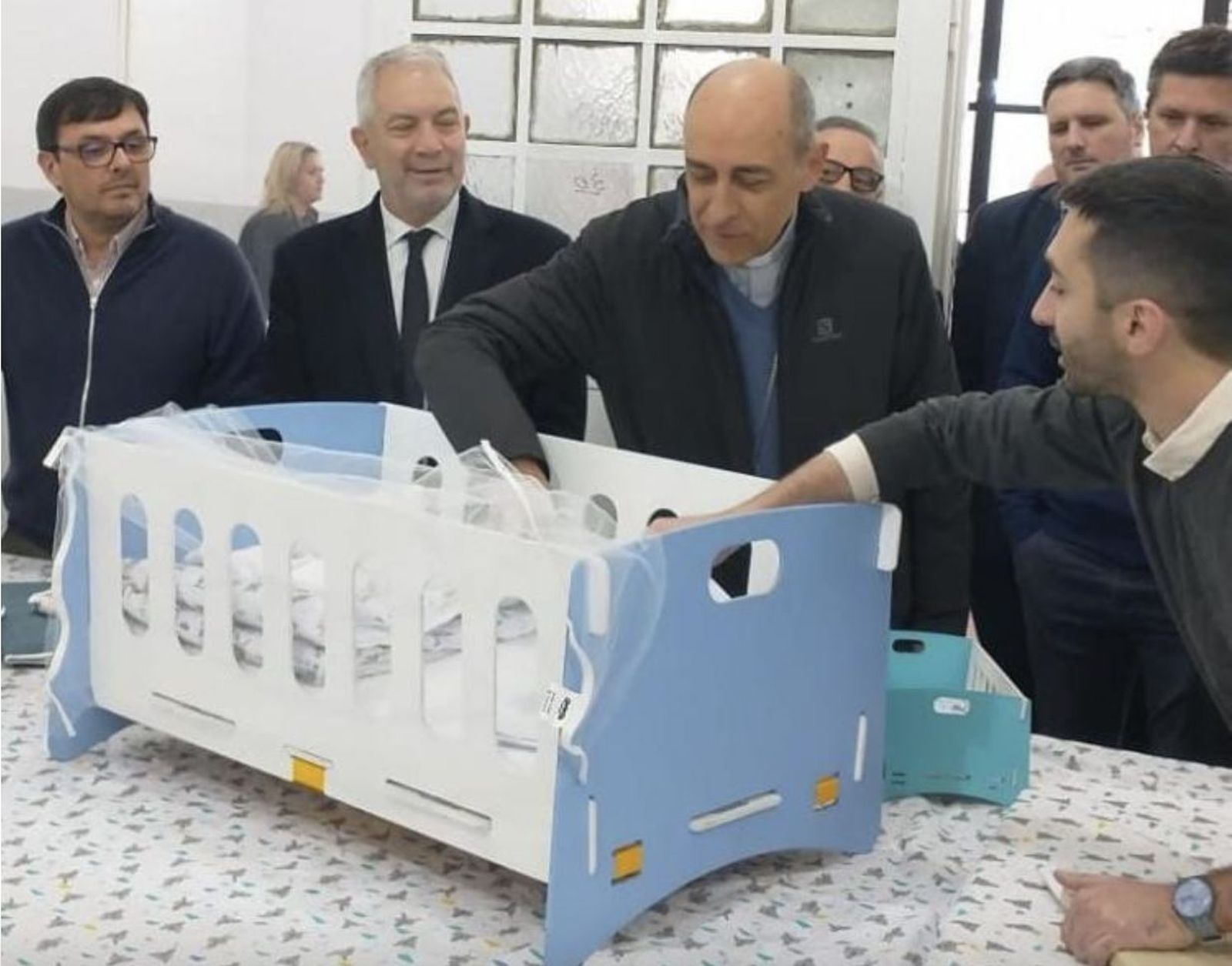 El arzobispo observa una de las cunas que fabrican los internos